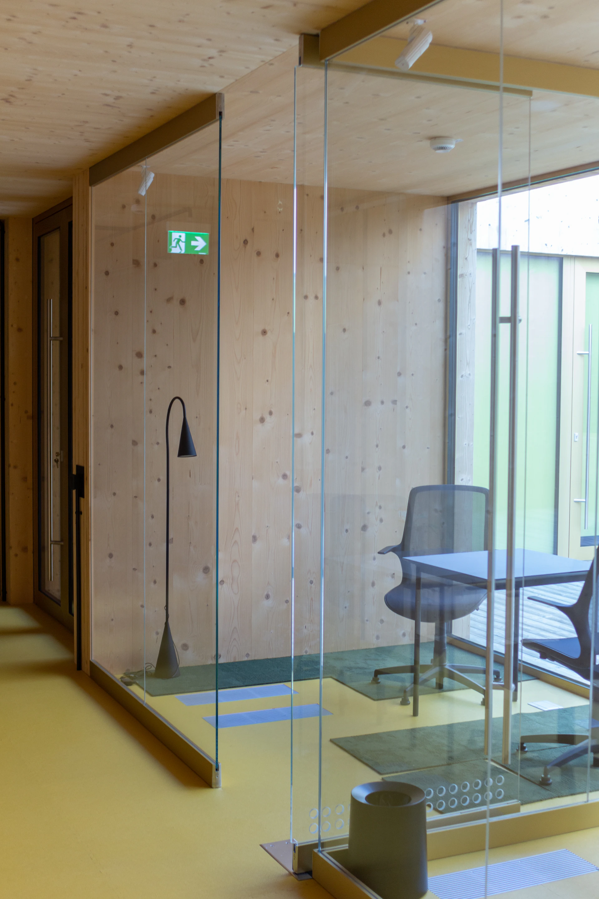Floor-to-ceiling glass partition enclosing a bright modern interior